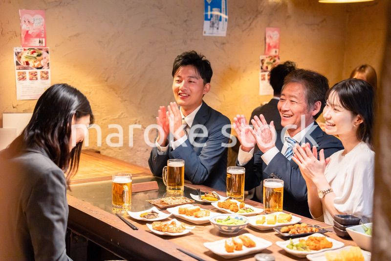 居酒屋でお祝いをするビジネスパーソン
