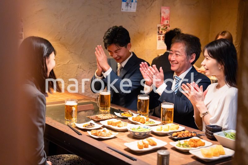 居酒屋でお祝いをするビジネスパーソン