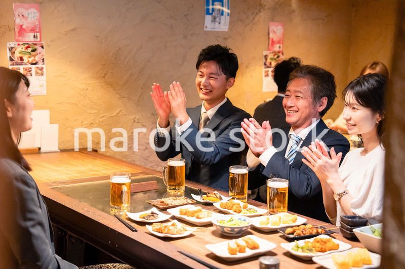 居酒屋でお祝いをするビジネスパーソン