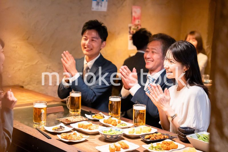 居酒屋でお祝いをするビジネスパーソン
