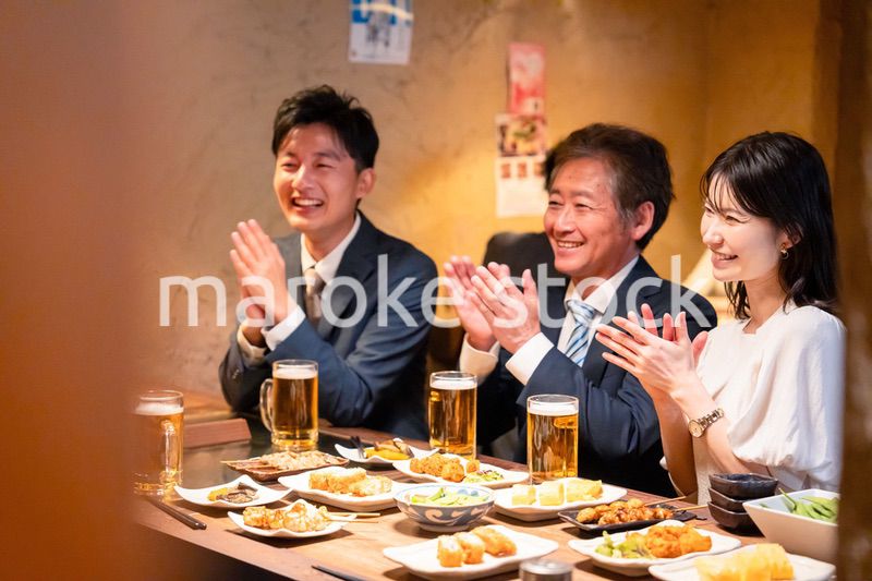 居酒屋でお祝いをするビジネスパーソン