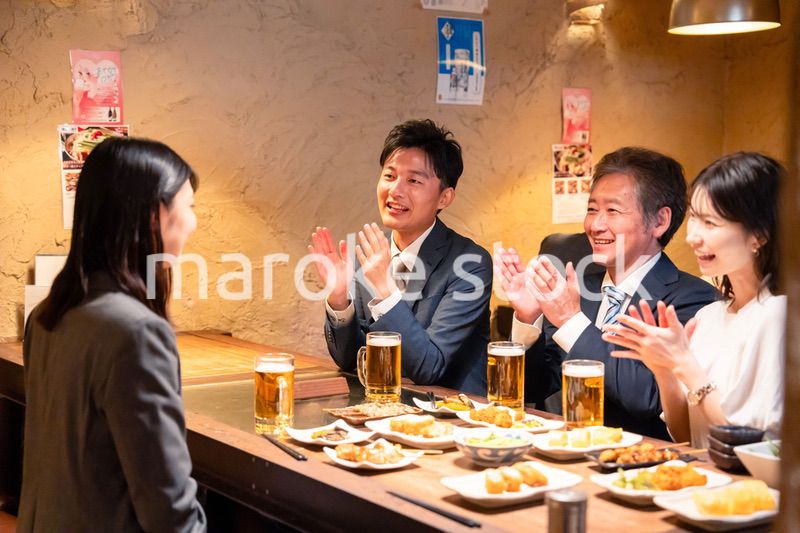 居酒屋でお祝いをするビジネスパーソン