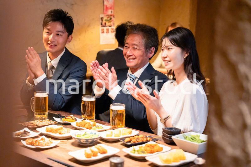 居酒屋でお祝いをするビジネスパーソン