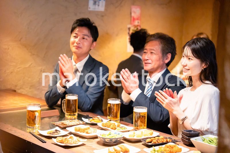 居酒屋でお祝いをするビジネスパーソン