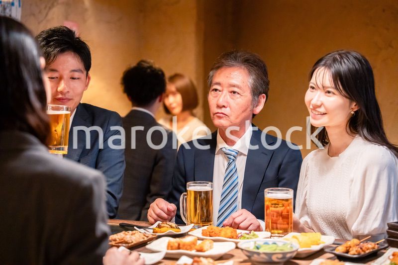 居酒屋で部署のお疲れ様会をするビジネスパーソン