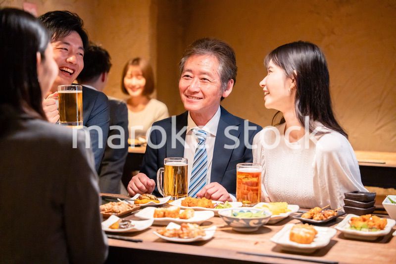 居酒屋で部署のお疲れ様会をするビジネスパーソン