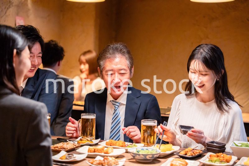 居酒屋で部署のお疲れ様会をするビジネスパーソン