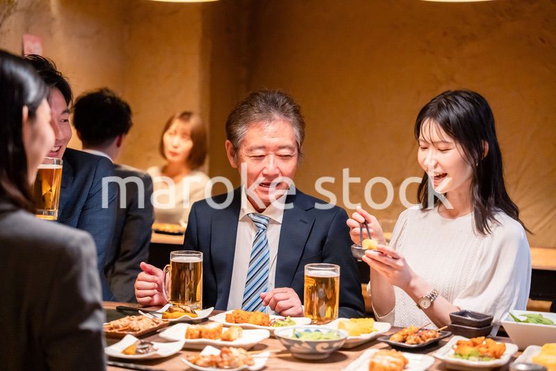 居酒屋で部署のお疲れ様会をするビジネスパーソン