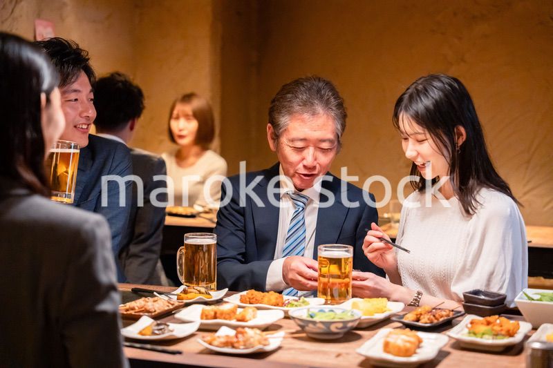 居酒屋で部署のお疲れ様会をするビジネスパーソン