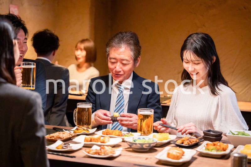 居酒屋で部署のお疲れ様会をするビジネスパーソン