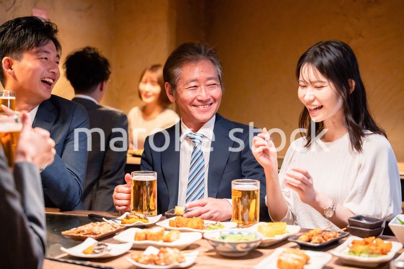 居酒屋で部署のお疲れ様会をするビジネスパーソン