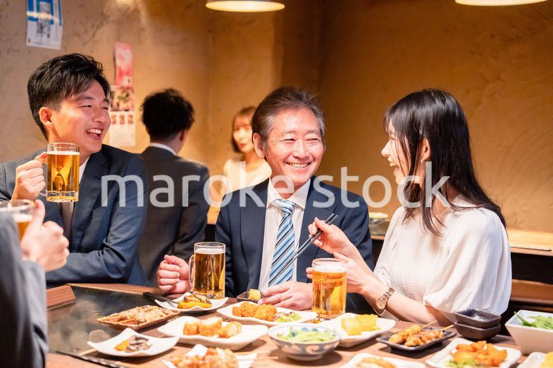 居酒屋で部署のお疲れ様会をするビジネスパーソン
