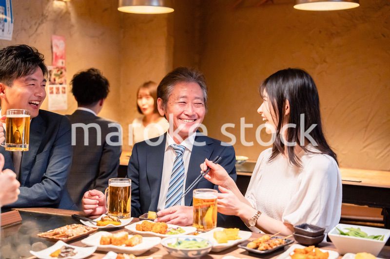 居酒屋で部署のお疲れ様会をするビジネスパーソン