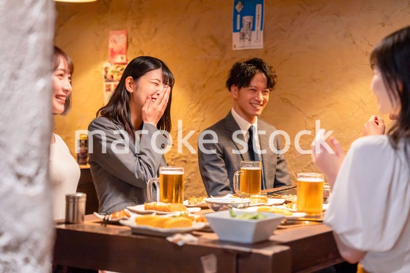 飲み会で大爆笑して盛り上がる会社員の女性