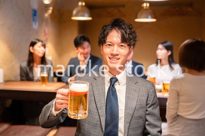 居酒屋でビールの乾杯をするサラリーマンの男性