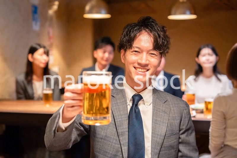 居酒屋でビールの乾杯をするサラリーマンの男性