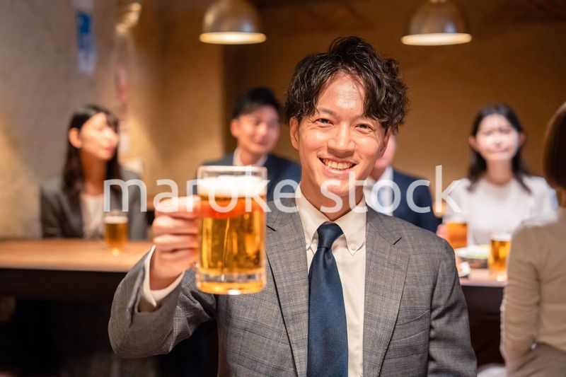 居酒屋でビールの乾杯をするサラリーマンの男性