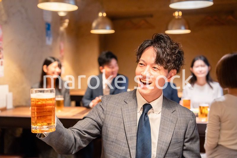 居酒屋でビールの乾杯をするサラリーマンの男性