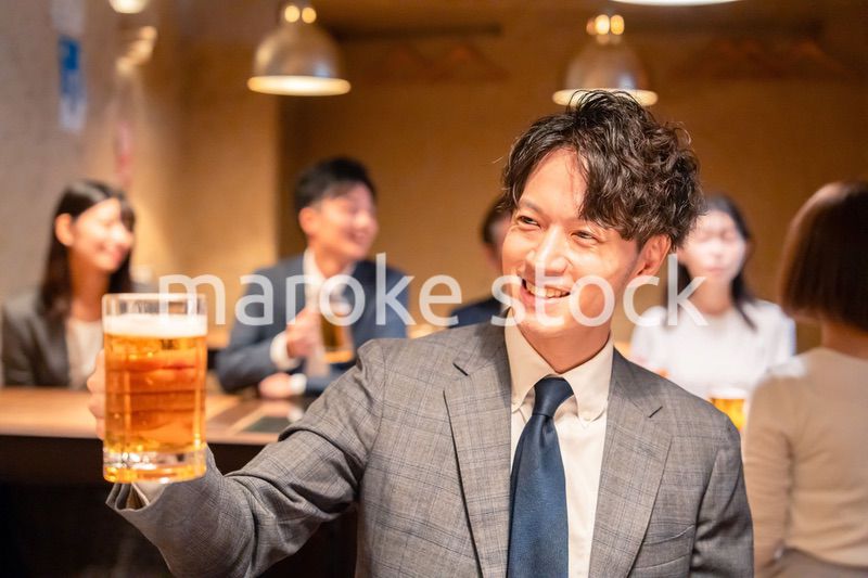 居酒屋でビールの乾杯をするサラリーマンの男性