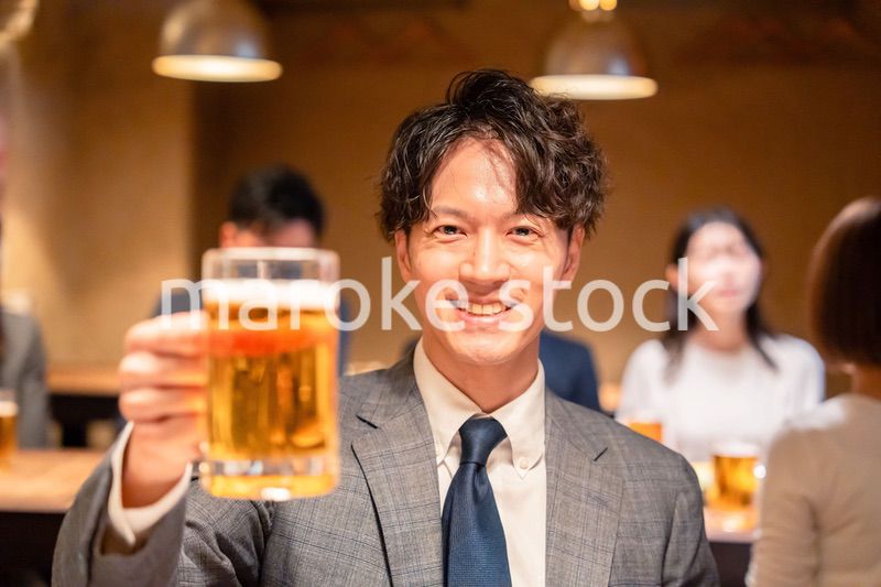 居酒屋でビールの乾杯をするサラリーマンの男性