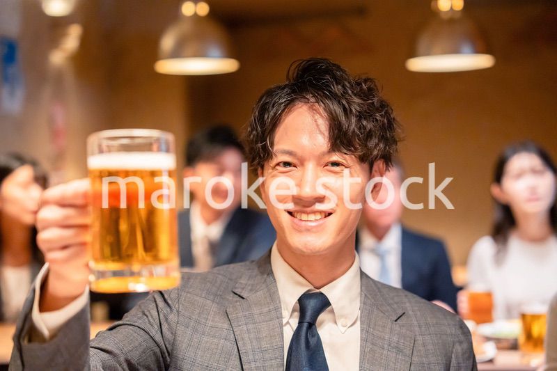 居酒屋でビールの乾杯をするサラリーマンの男性