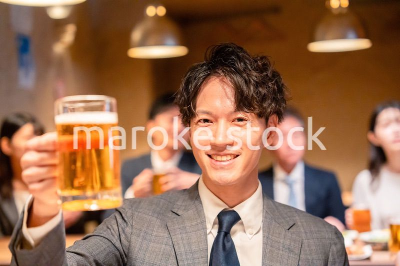居酒屋でビールの乾杯をするサラリーマンの男性