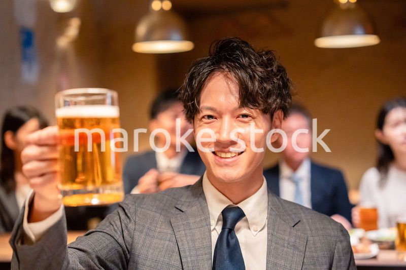 居酒屋でビールの乾杯をするサラリーマンの男性