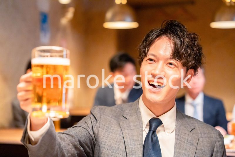 居酒屋でビールの乾杯をするサラリーマンの男性