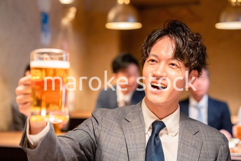 居酒屋でビールの乾杯をするサラリーマンの男性