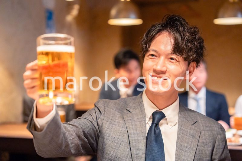 居酒屋でビールの乾杯をするサラリーマンの男性