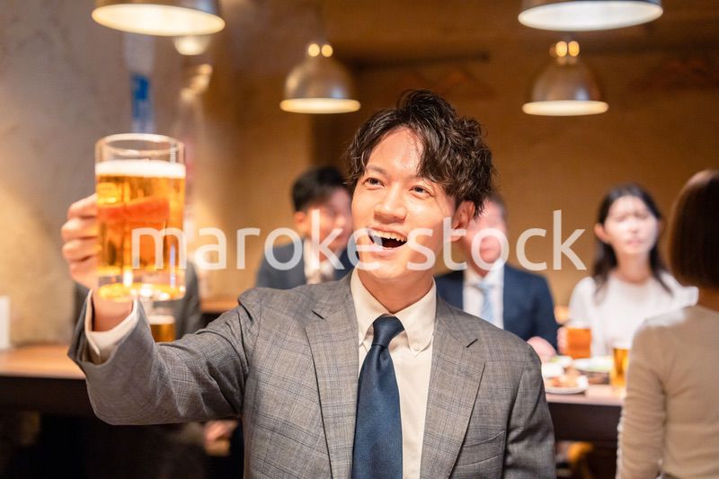 居酒屋でビールの乾杯をするサラリーマンの男性