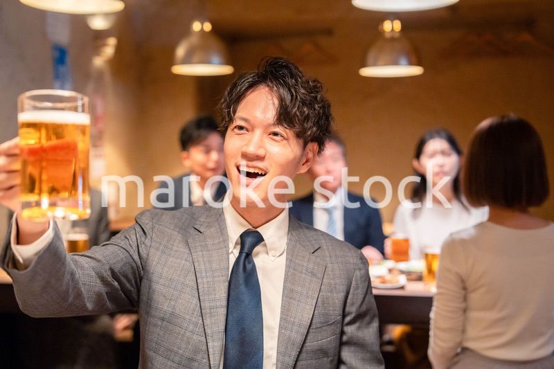 居酒屋でビールの乾杯をするサラリーマンの男性