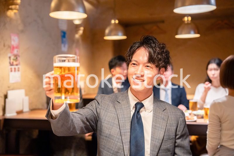 居酒屋でビールの乾杯をするサラリーマンの男性