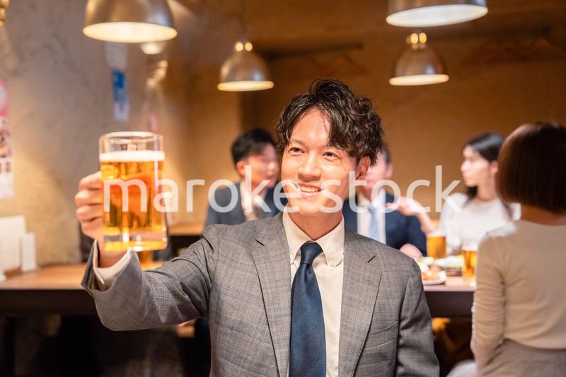 居酒屋でビールの乾杯をするサラリーマンの男性
