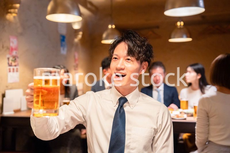 居酒屋でビールの乾杯をするサラリーマンの男性
