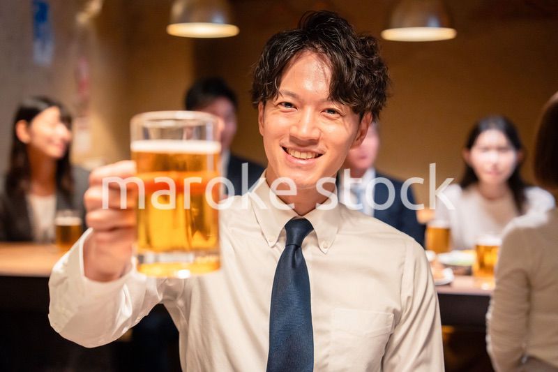 居酒屋でビールの乾杯をするサラリーマンの男性