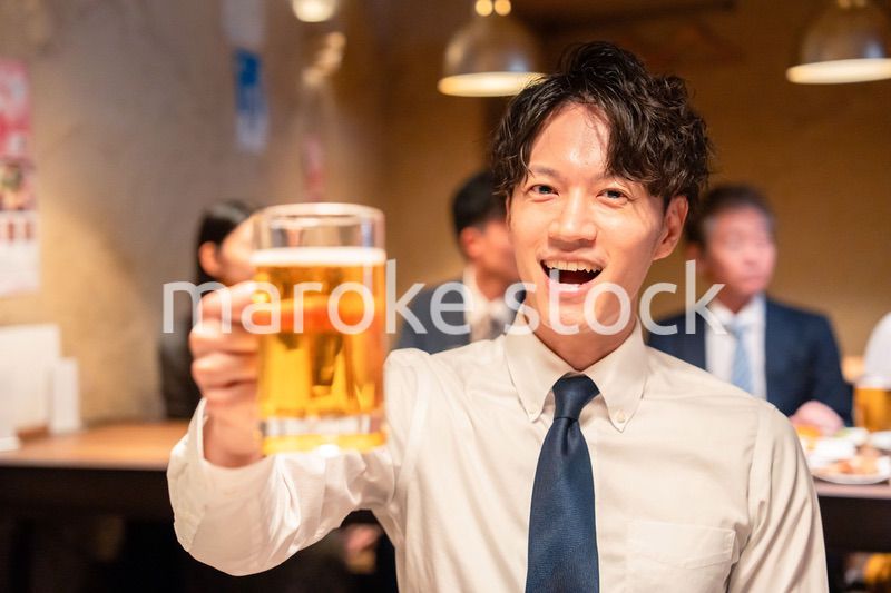 居酒屋でビールの乾杯をするサラリーマンの男性