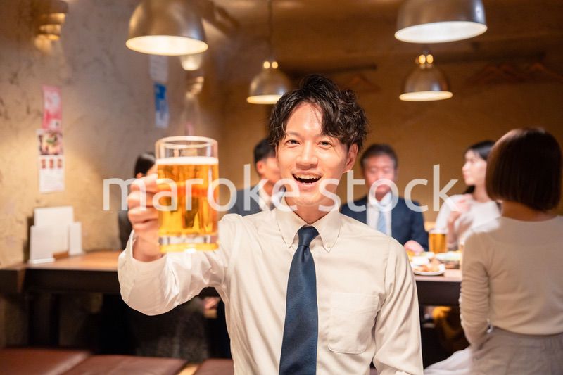居酒屋でビールの乾杯をするサラリーマンの男性