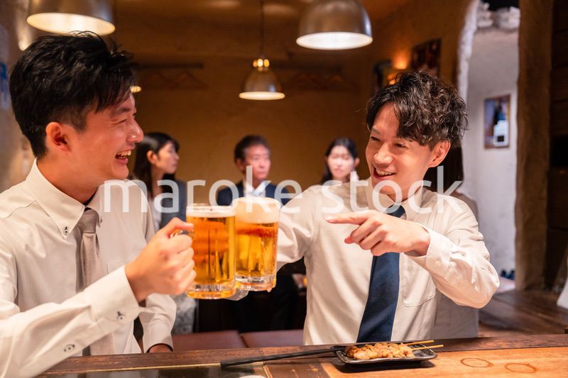 居酒屋でビールを飲む二人の若手ビジネスマン