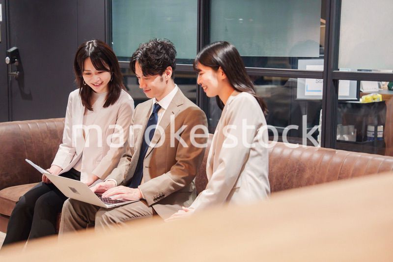 オフィスのソファーでカジュアルに打ち合わせをするビジネスパーソン