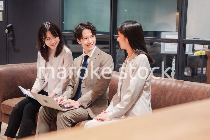 オフィスのソファーでカジュアルに打ち合わせをするビジネスパーソン