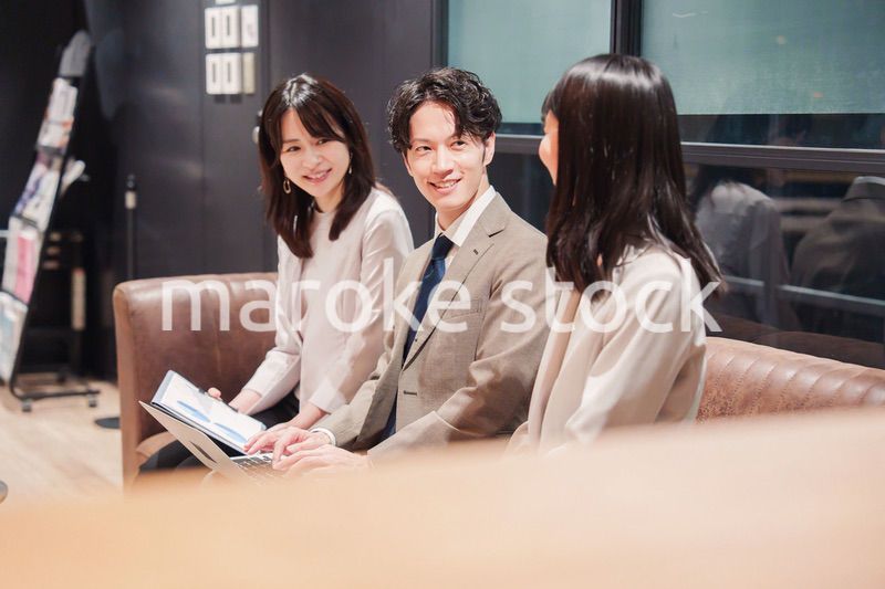 オフィスのソファーでカジュアルに打ち合わせをするビジネスパーソン