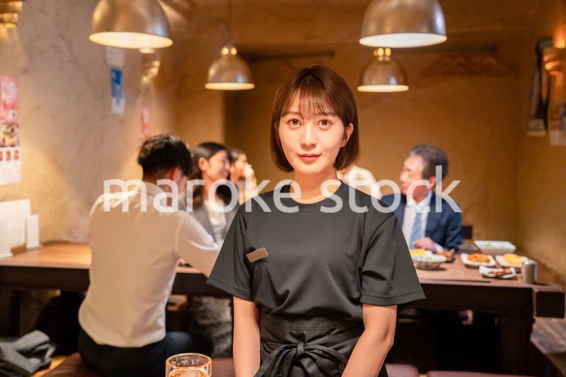 居酒屋のホールで働く若い女性