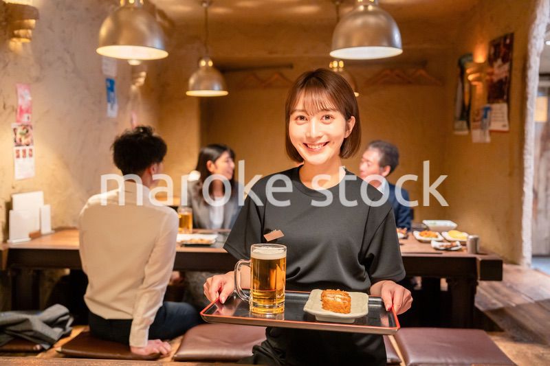 居酒屋のホールで働く若い女性