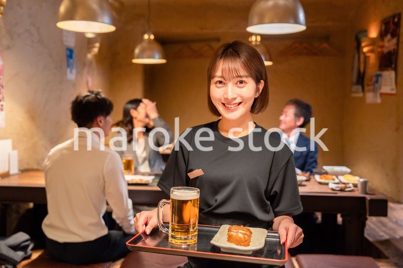 居酒屋のホールで働く若い女性
