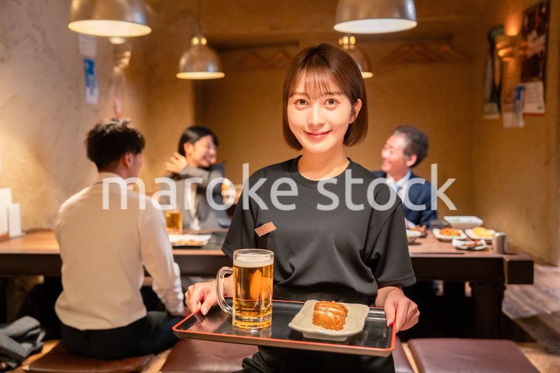 居酒屋のホールで働く若い女性