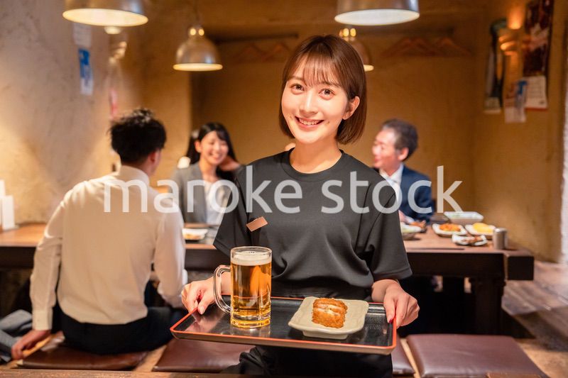 居酒屋のホールで働く若い女性