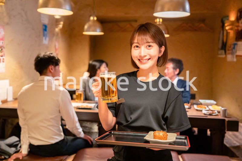 居酒屋のホールで働く若い女性