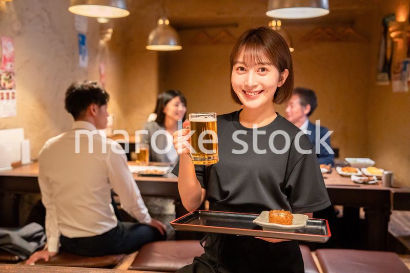 居酒屋のホールで働く若い女性