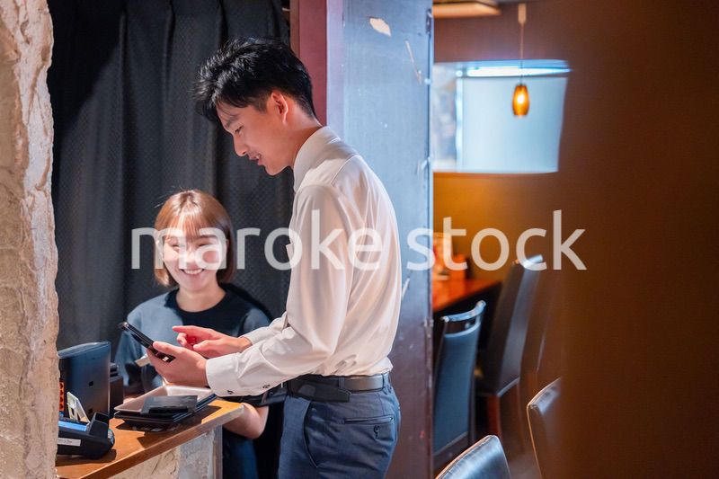 居酒屋でレジ打ちをする店員